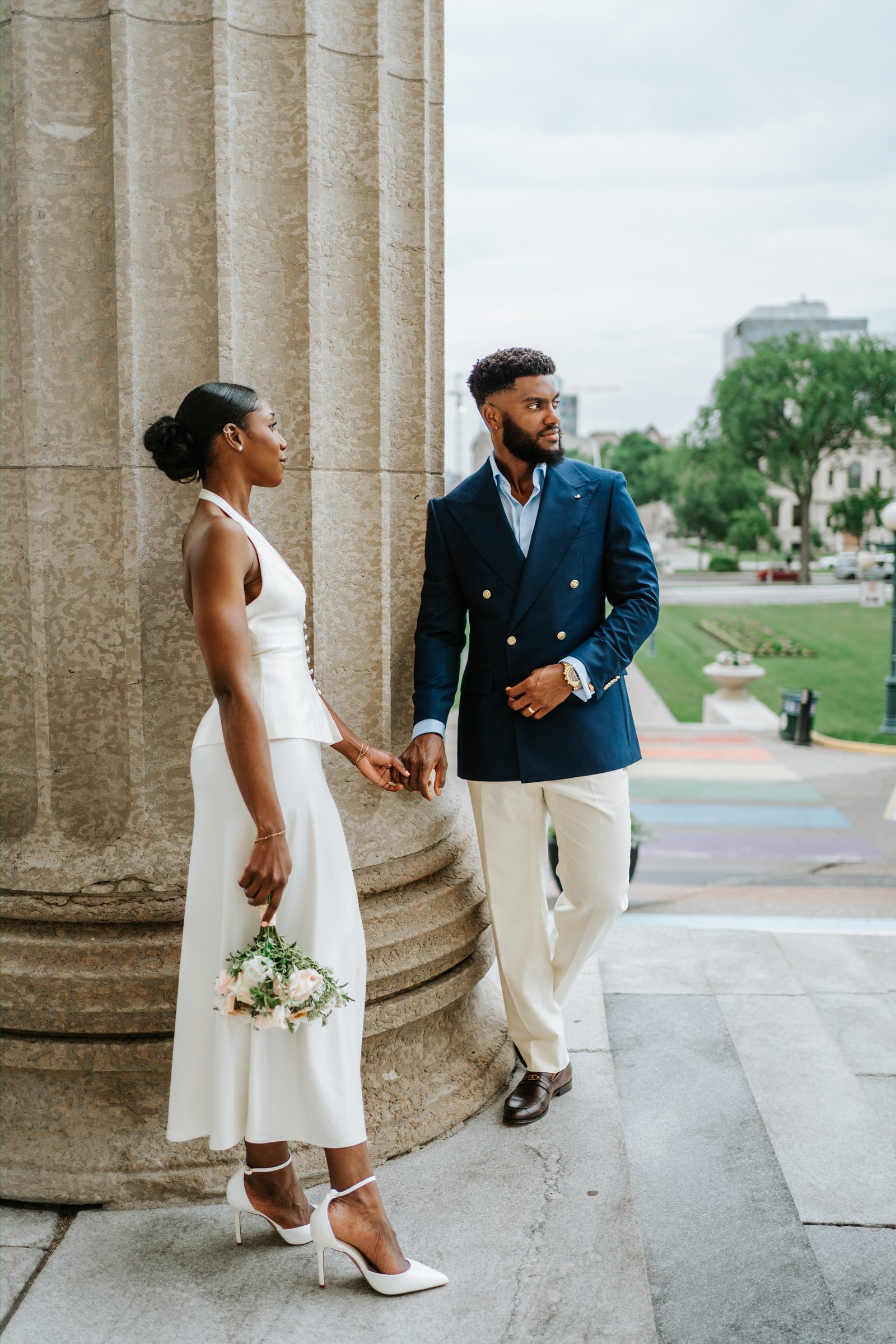 Tobi and Emeka with guests on the exterior steps of the Manitoba Legislative Building, Winnipeg — family portrait before the drive to Assiniboine Park