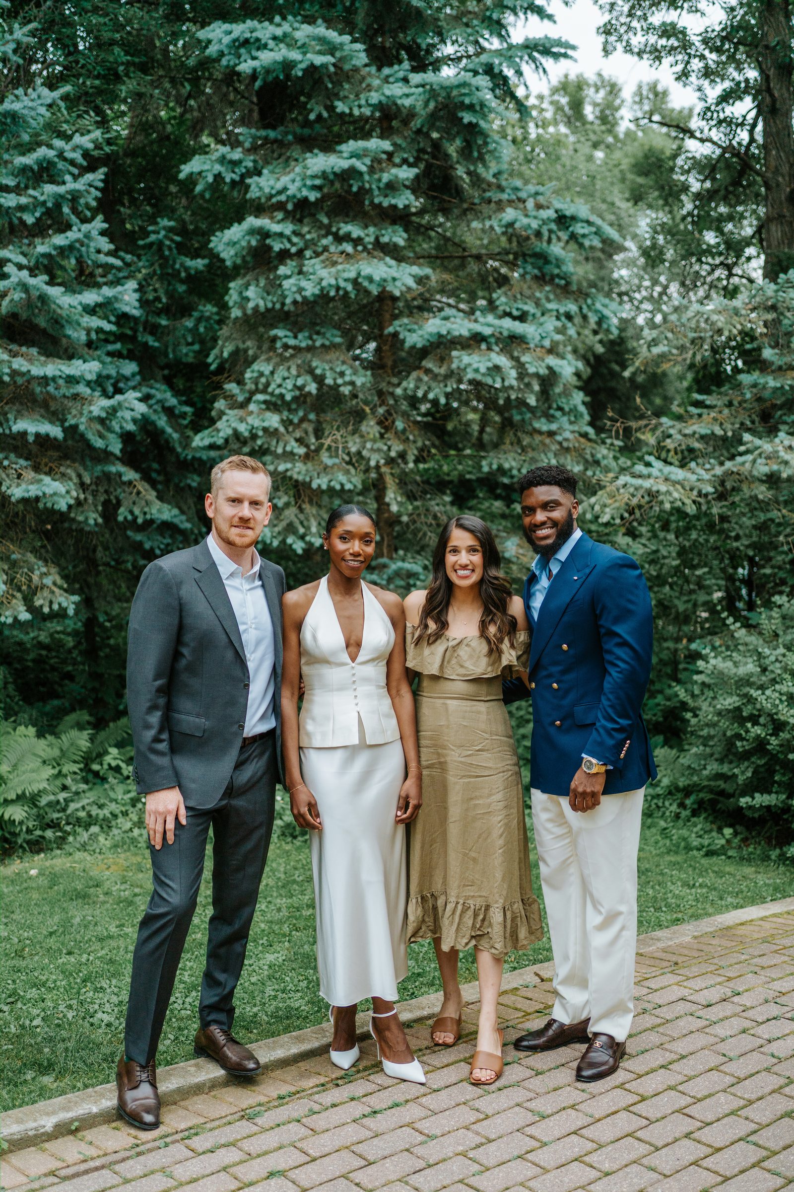 Group portrait at Leo Mol Sculpture Garden in Assiniboine Park, Winnipeg — Tobi and Emeka with two guests in front of the lush green garden trees