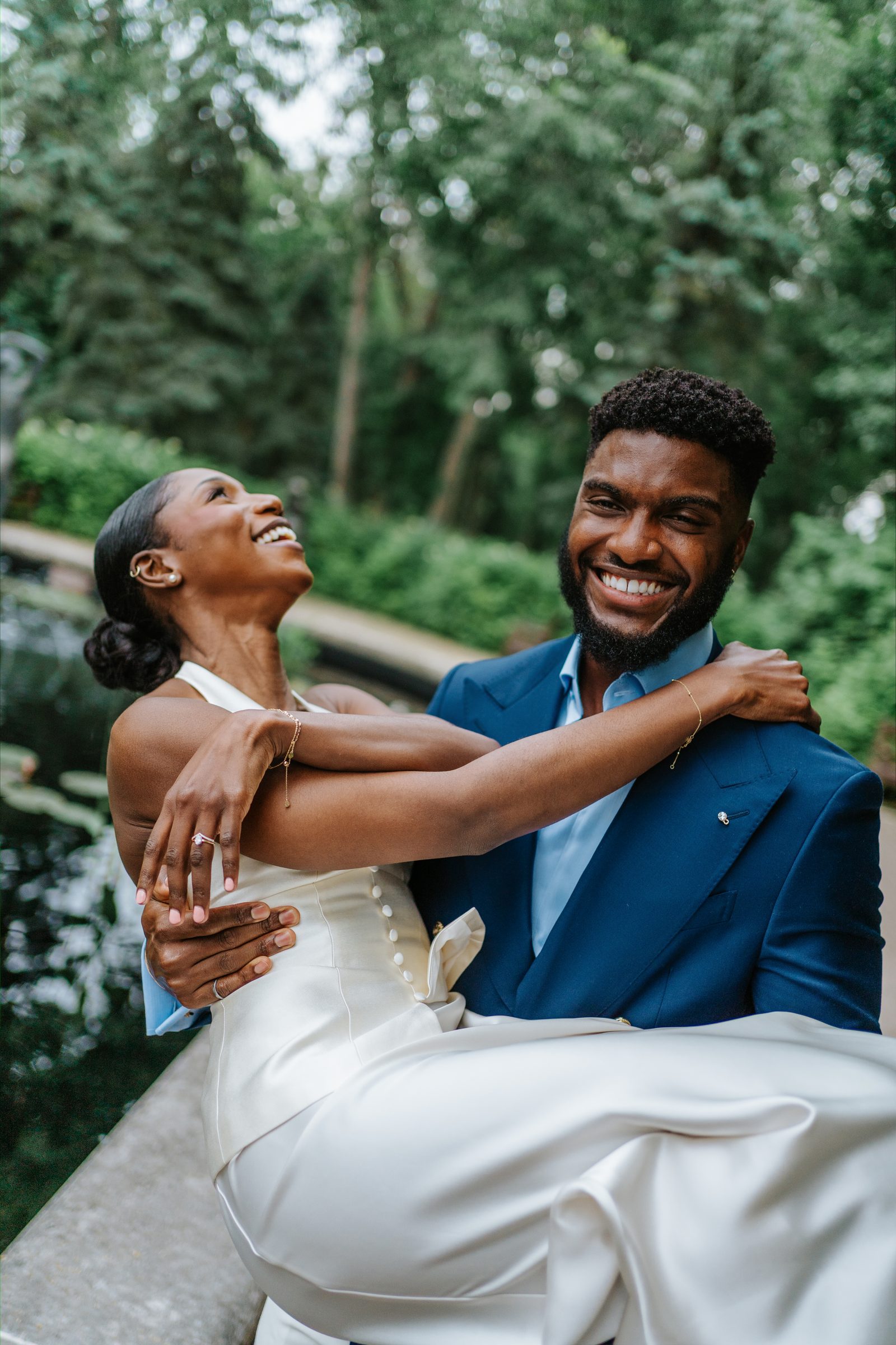 Tobi and Emeka portrait at Leo Mol Sculpture Garden — couple in the lush green July garden, Assiniboine Park, Winnipeg
