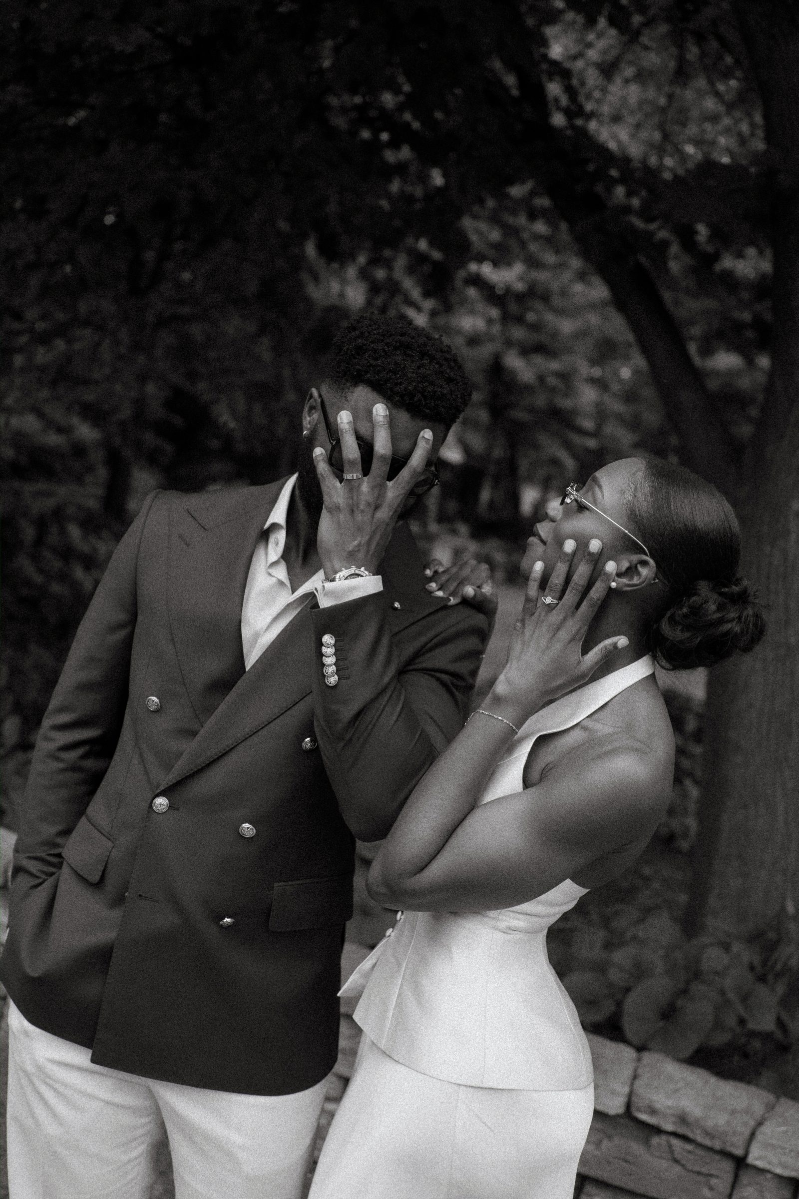 Emeka carrying Tobi along the lily pond path at Leo Mol Sculpture Garden in Assiniboine Park, Winnipeg — both laughing, post-ceremony couple portrait by Chris Ngo, Ngo Photography