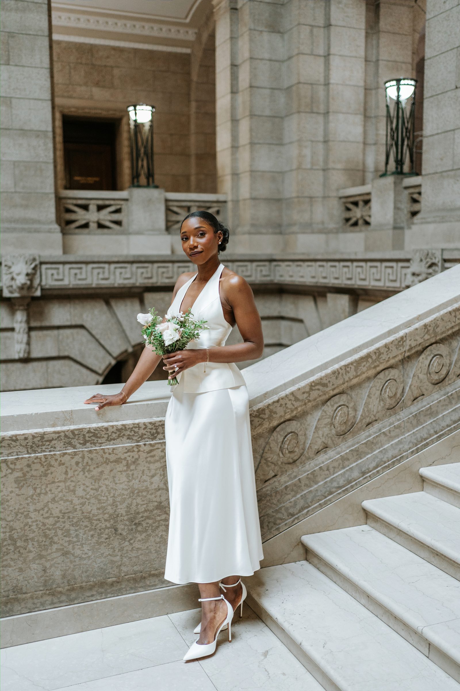 Tobi and Emeka together on the Legislative Building staircase — intimate couple portrait in the marble rotunda, Winnipeg, Manitoba