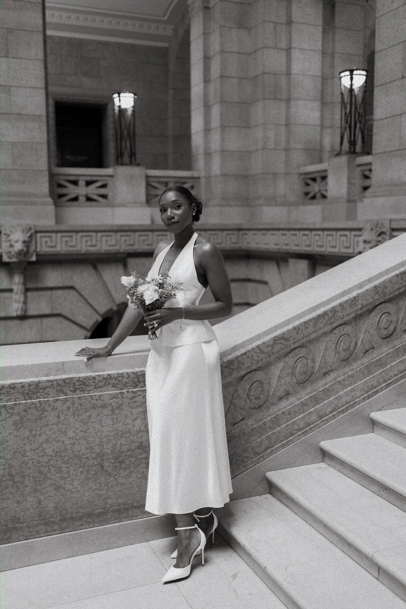 Tobi and Emeka on the marble steps of the Manitoba Legislative Building — editorial couple portrait, Winnipeg wedding photography