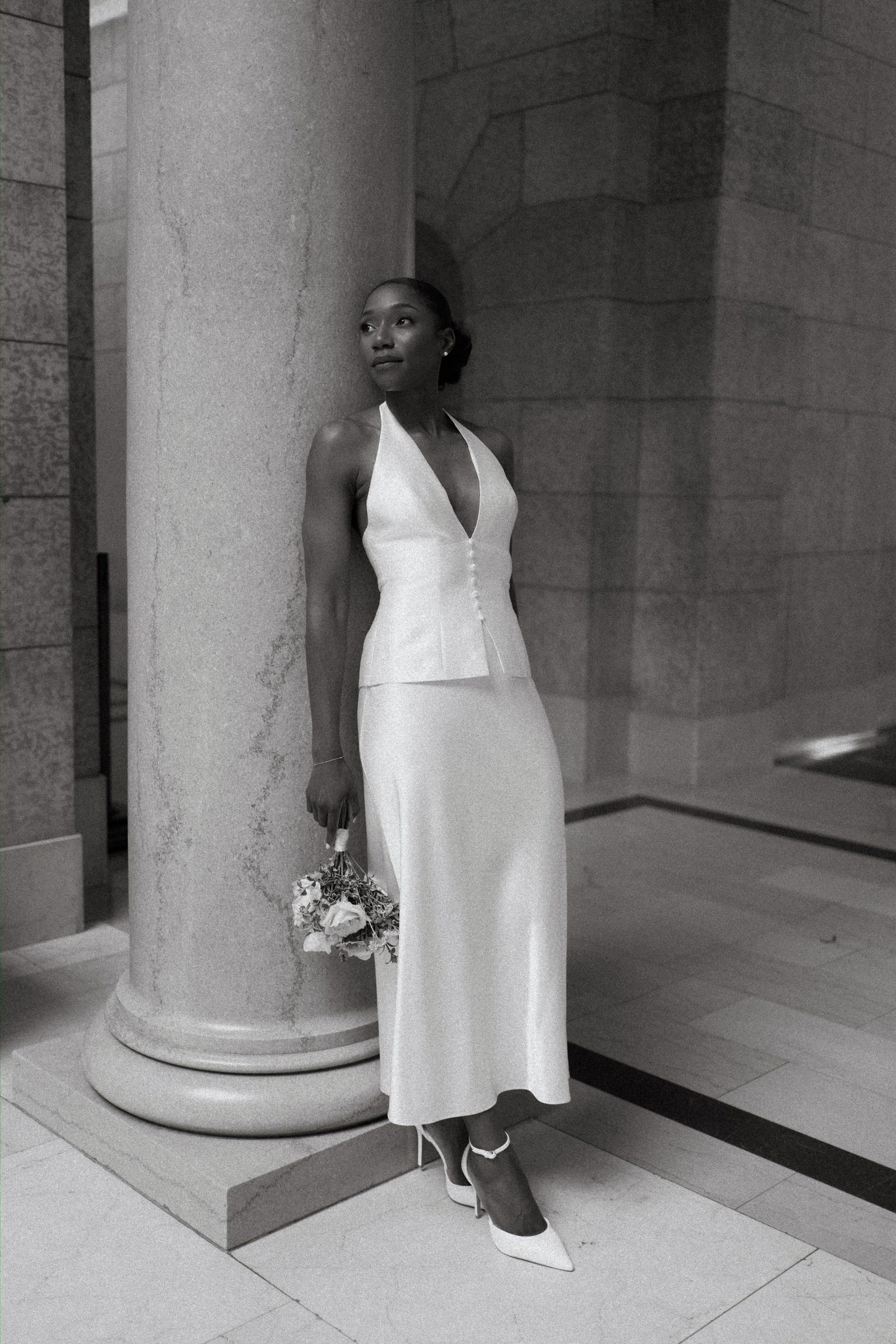Tobi and Emeka in the arched corridor of the Manitoba Legislative Building — Winnipeg wedding photographer Ngo Photography