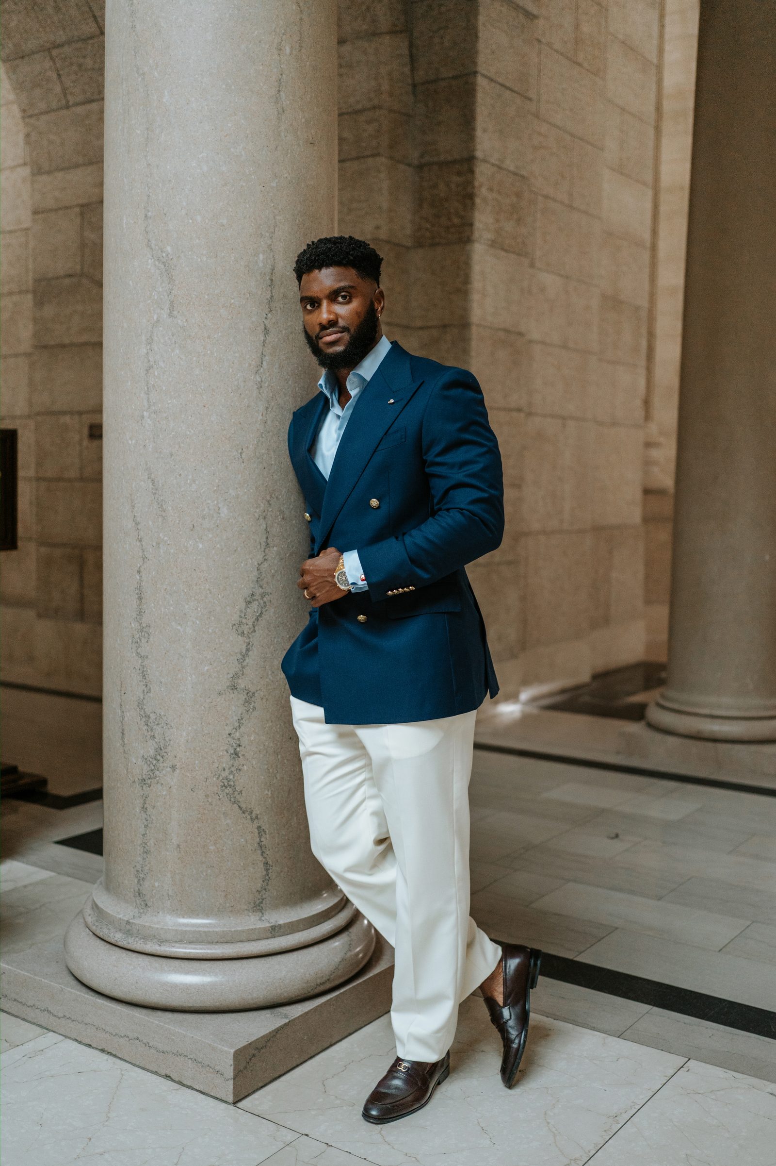 Tobi and Emeka together on the exterior steps of the Manitoba Legislative Building — couple portrait between stone columns, Winnipeg
