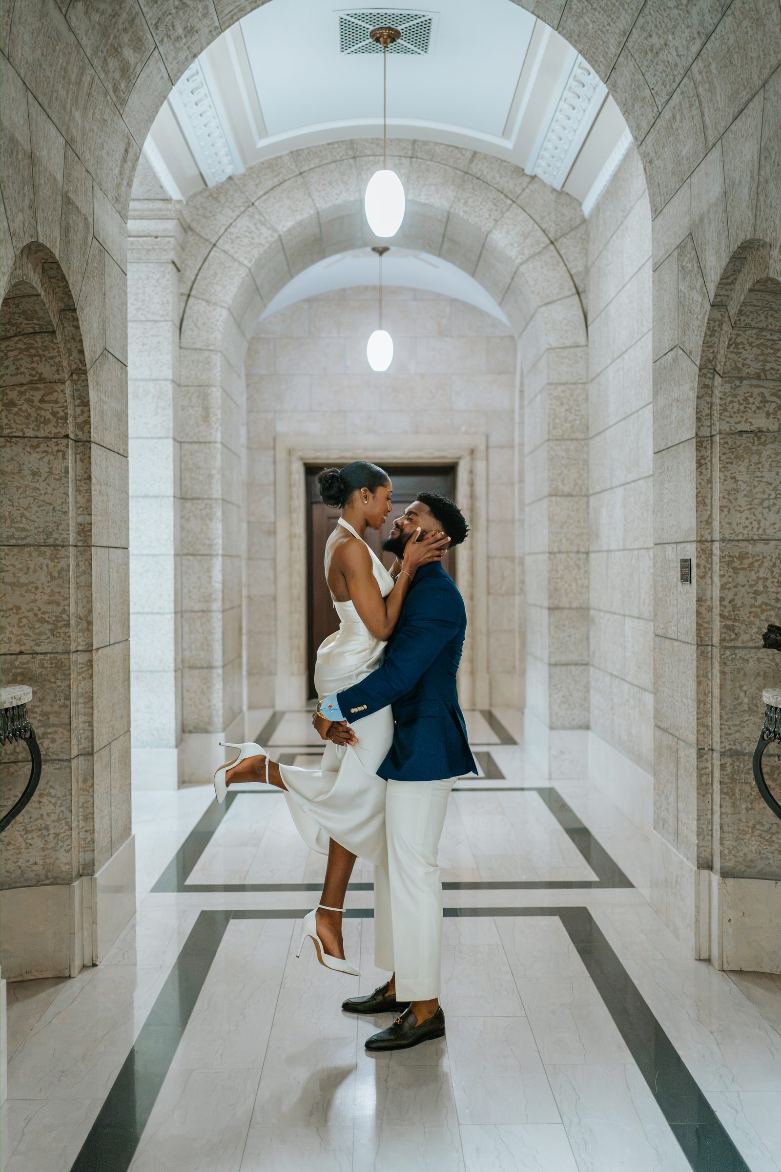 Tobi and Emeka on the exterior marble steps of the Manitoba Legislative Building — couple portrait with classical stone architecture, Winnipeg