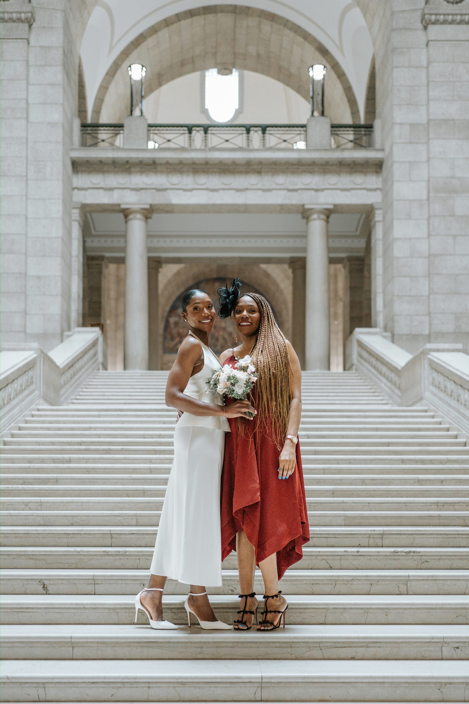 Emeka and Tobi at the Manitoba Legislative Building exterior — couple portrait in the colonnade, Winnipeg